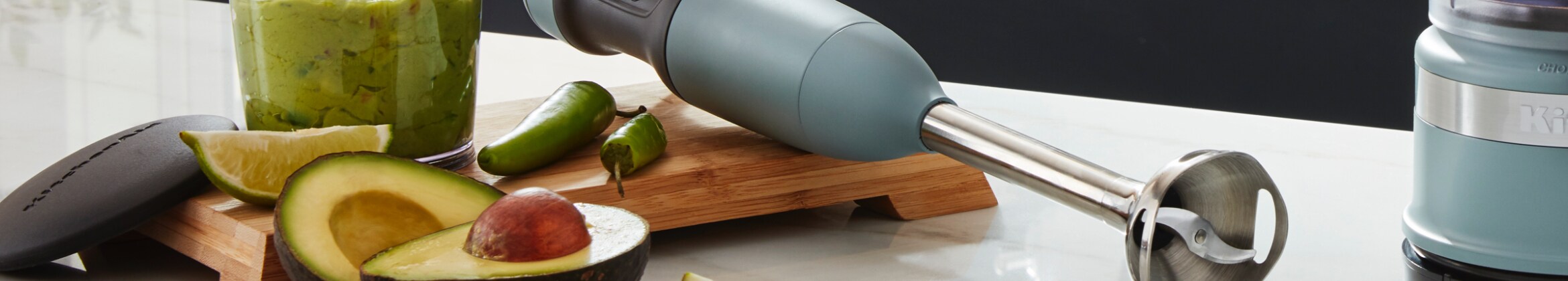 KitchenAid Immersion Hand Blender on a counter next to an Avocado