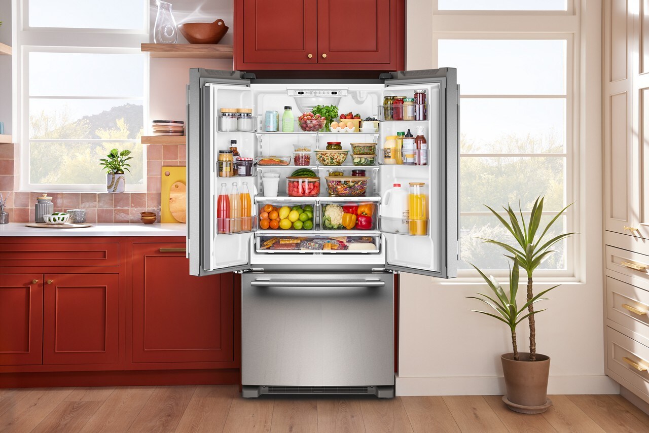 An opened KitchenAid®  French door refrigerator in a rustic kitchen