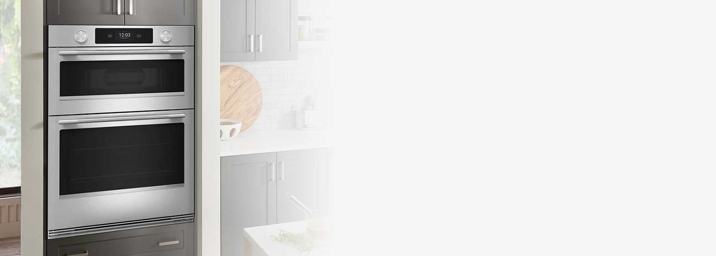 KitchenAid® combo wall oven in a kitchen with gray cabinetry and white countertops