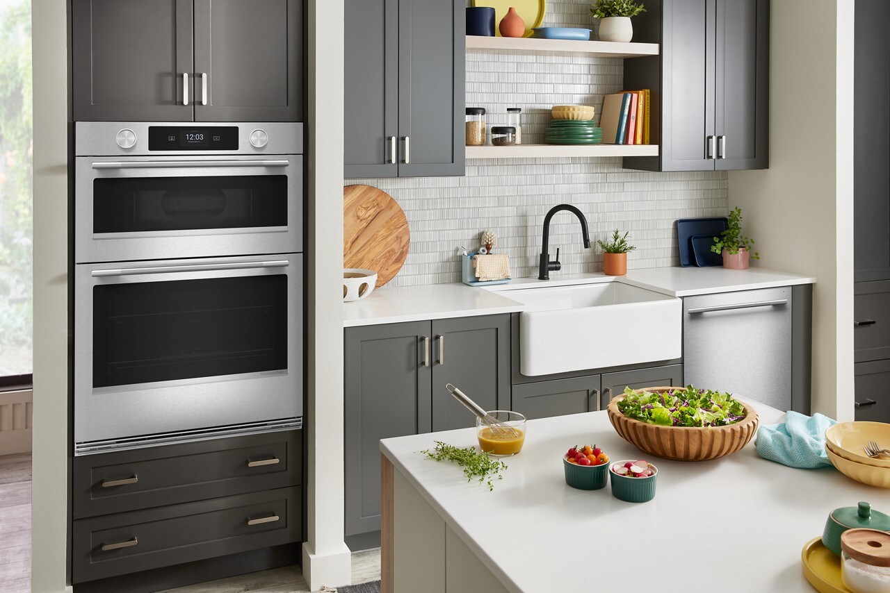 KitchenAid® combo wall oven in a kitchen with gray cabinetry and white countertops