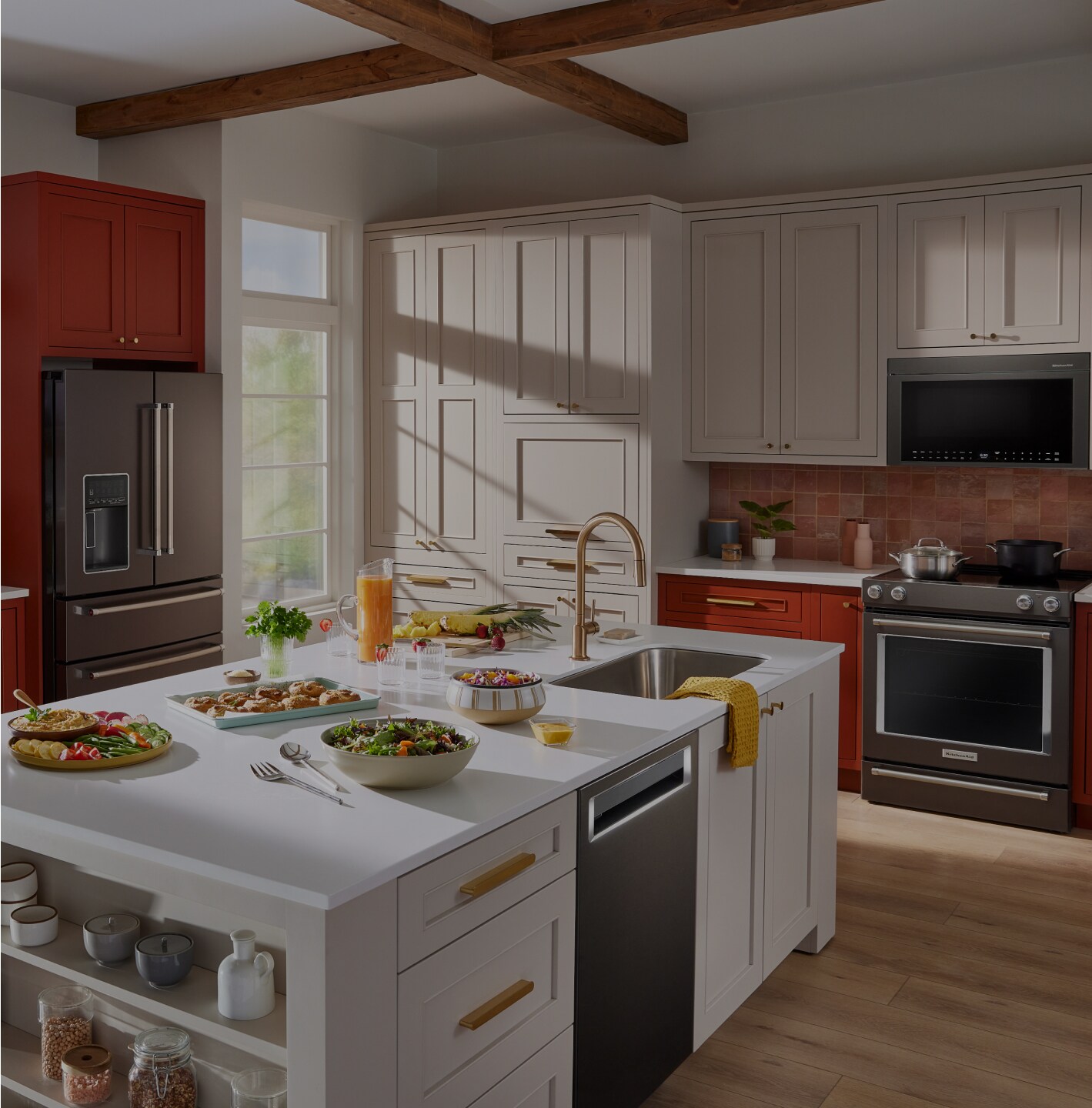 A kitchen in red and white, featuring KitchenAid appliances.