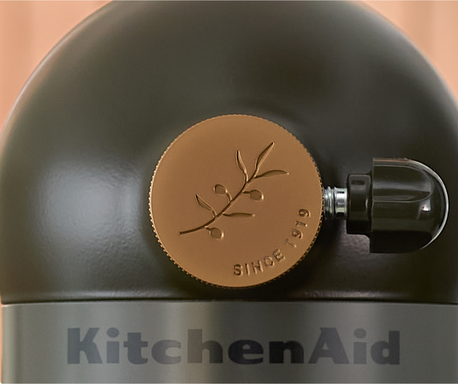 A close up of the Evergreen stand mixer’s hub cap and trim band.