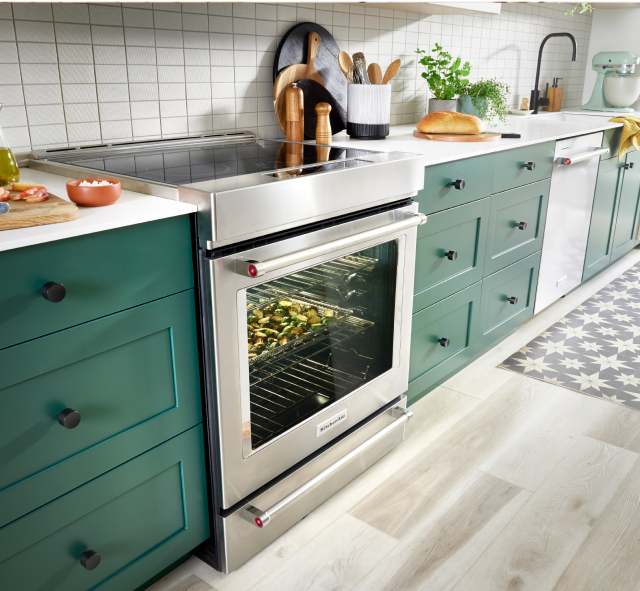 Une cuisine vibrante, vert émeraude et blanche, équipée d'une cuisinière KitchenAid®.