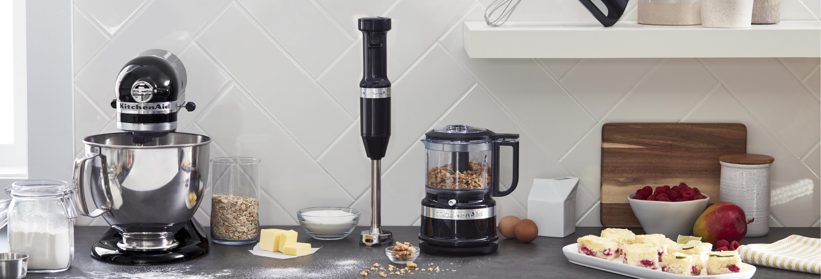 KitchenAid® refurbished appliances on a counter including a refurbished stand mixer, hand blender, and food chopper.