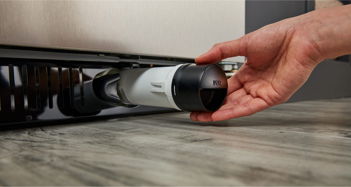 A person removing the water filter