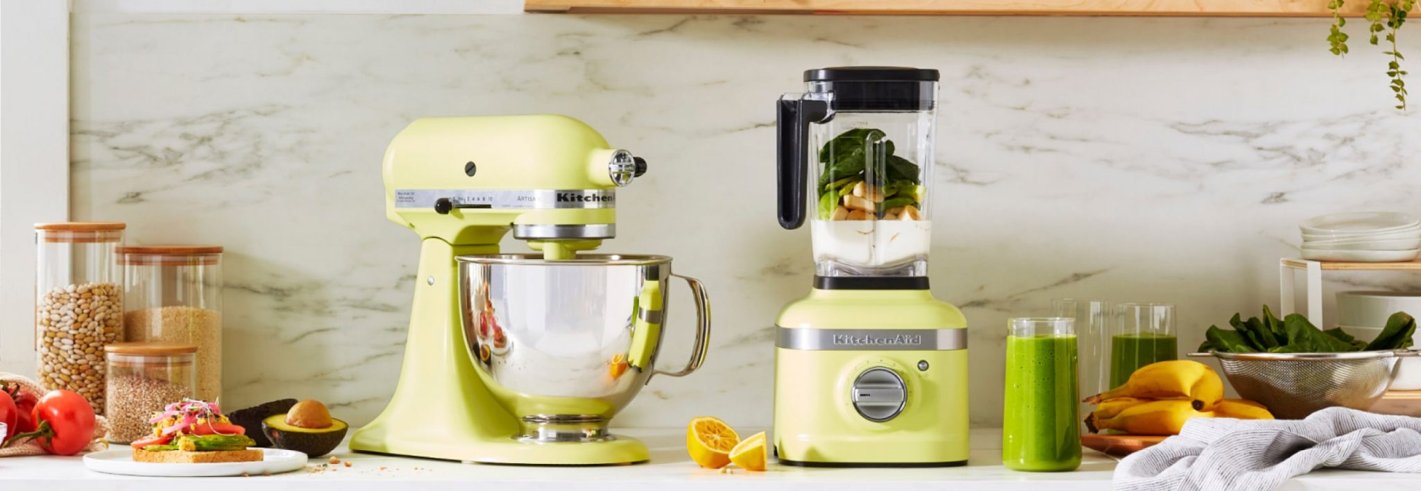 The Kyoto Glow stand mixer and blender on a white countertop surrounded by ingredients and prepared recipes.