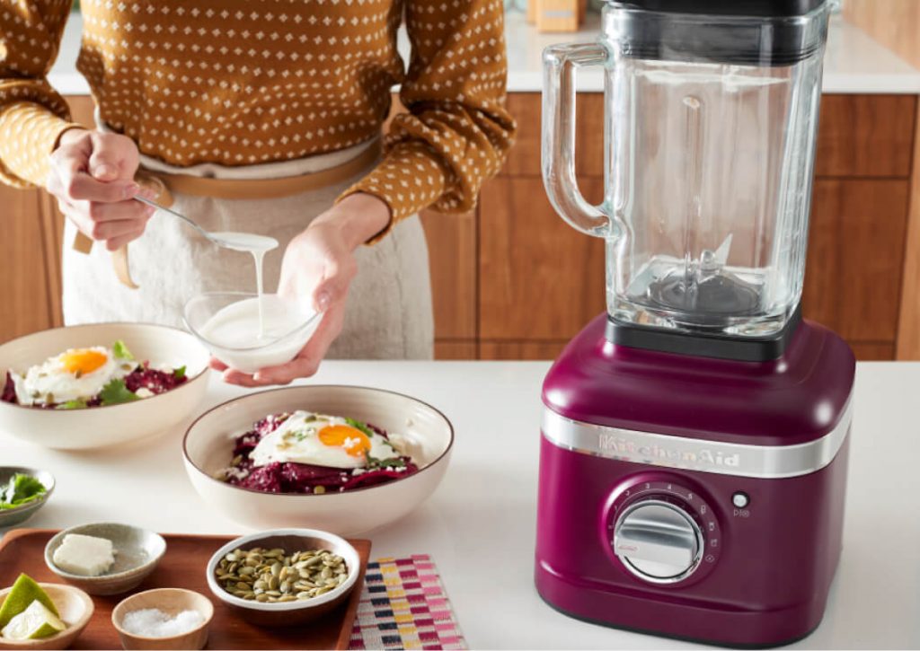 A Beetroot blender on a counter near two egg-topped bowls of food.