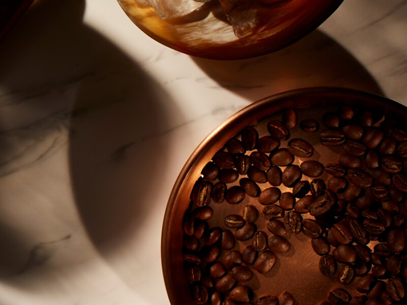  On a marble counter is a dish of coffee beans. 