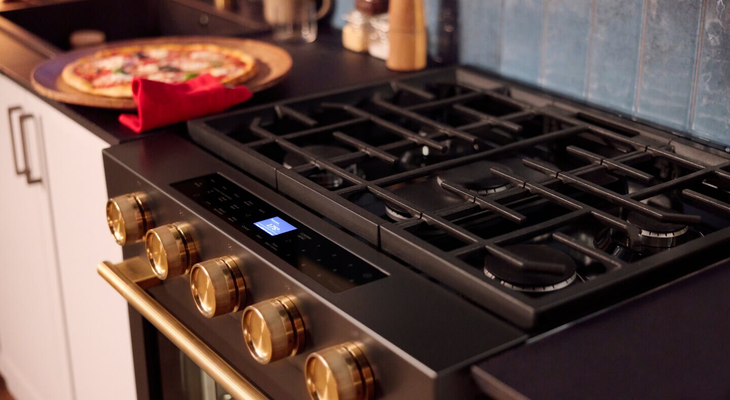 Une cuisine avec une cuisinière encastrée au gaz KitchenAid® dotée d'un réglage pour pizza à côté