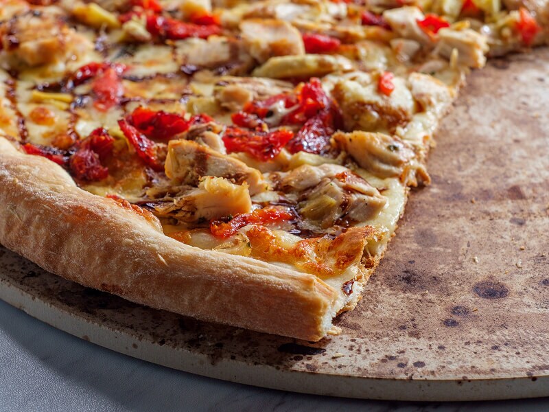 Une pizza cuite sur une pierre à pizza