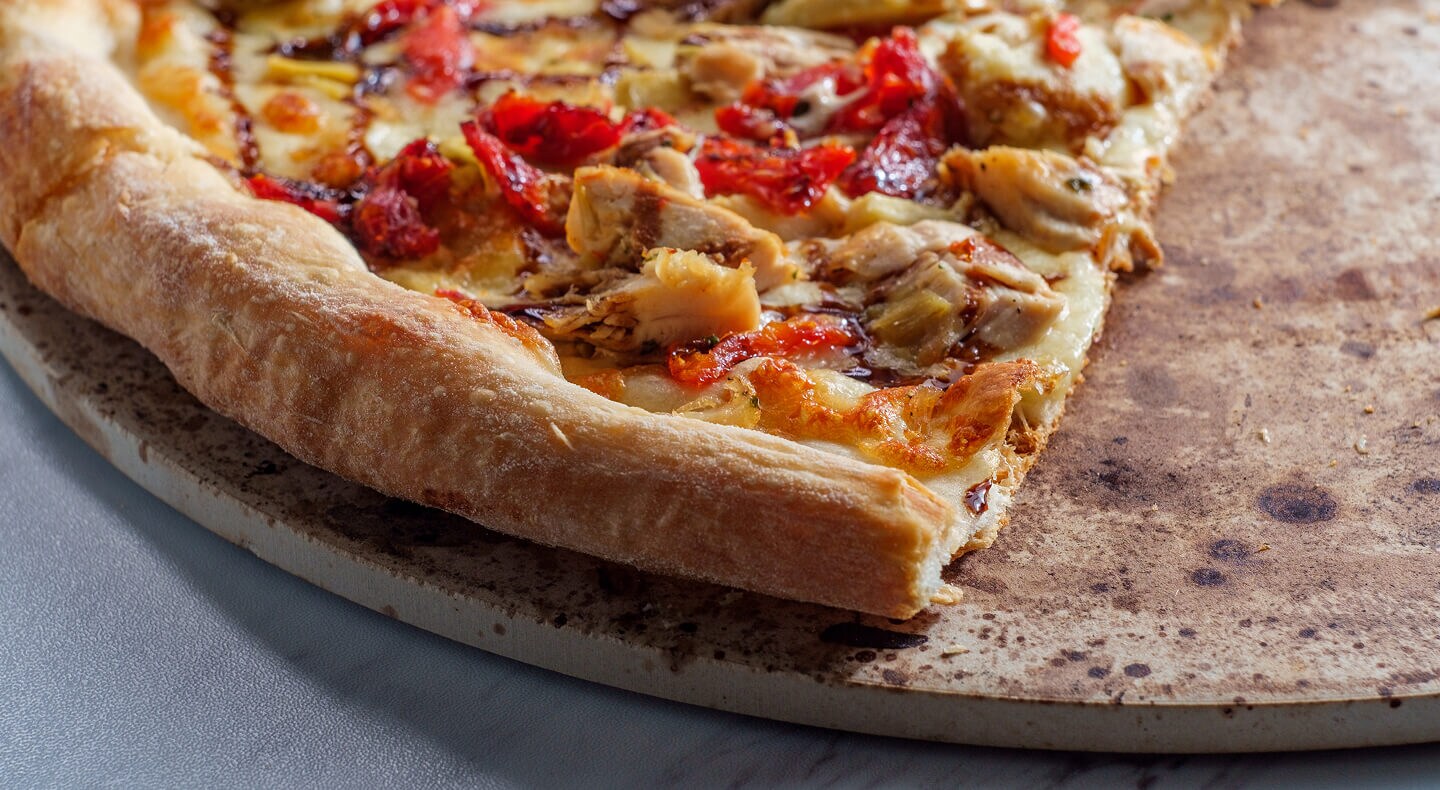 Une pizza cuite sur une pierre à pizza