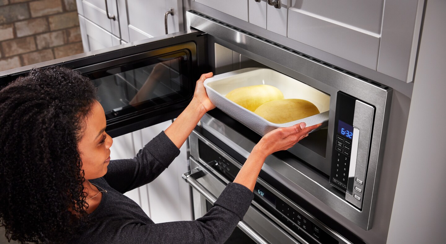 Une personne place des aliments dans un four à micro-ondes