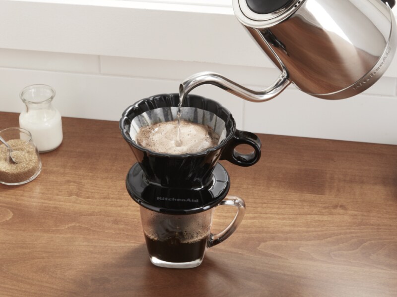 De l'eau bouillante provenant d'une bouilloire électrique est ajoutée au café moulu dans un filtre de café à verser.