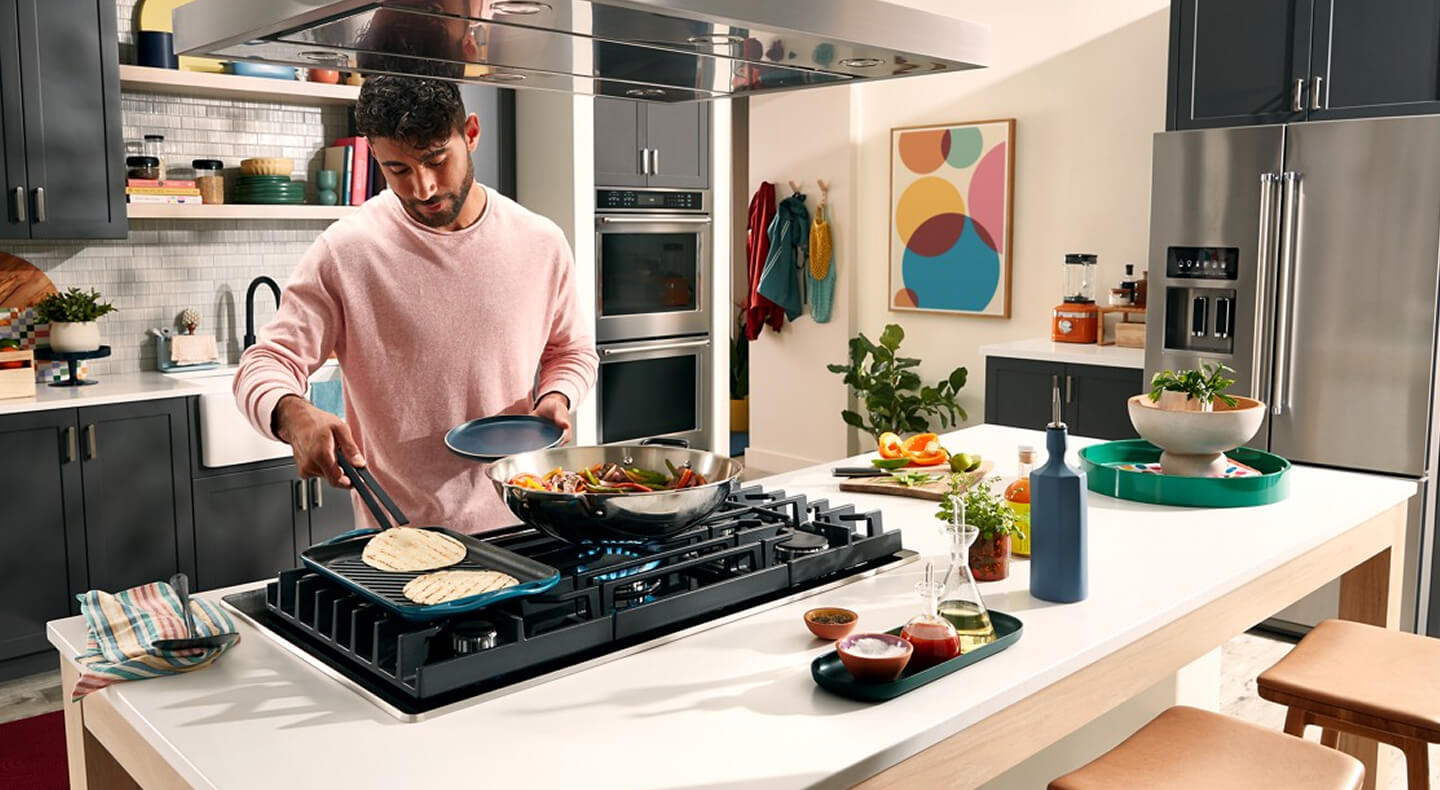 Une personne cuisine sur l'accessoire de plaque chauffante d'une cuisinière au gaz