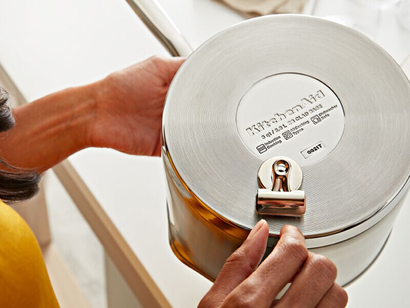 Une personne effectue le test de l'aimant sur une batterie de cuisine KitchenAid®