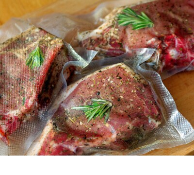 Trois morceaux de viande assaisonnés au romarin dans des sacs sous vide.