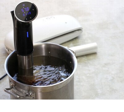 Une marmite d’eau contenant un circulateur sous vide.