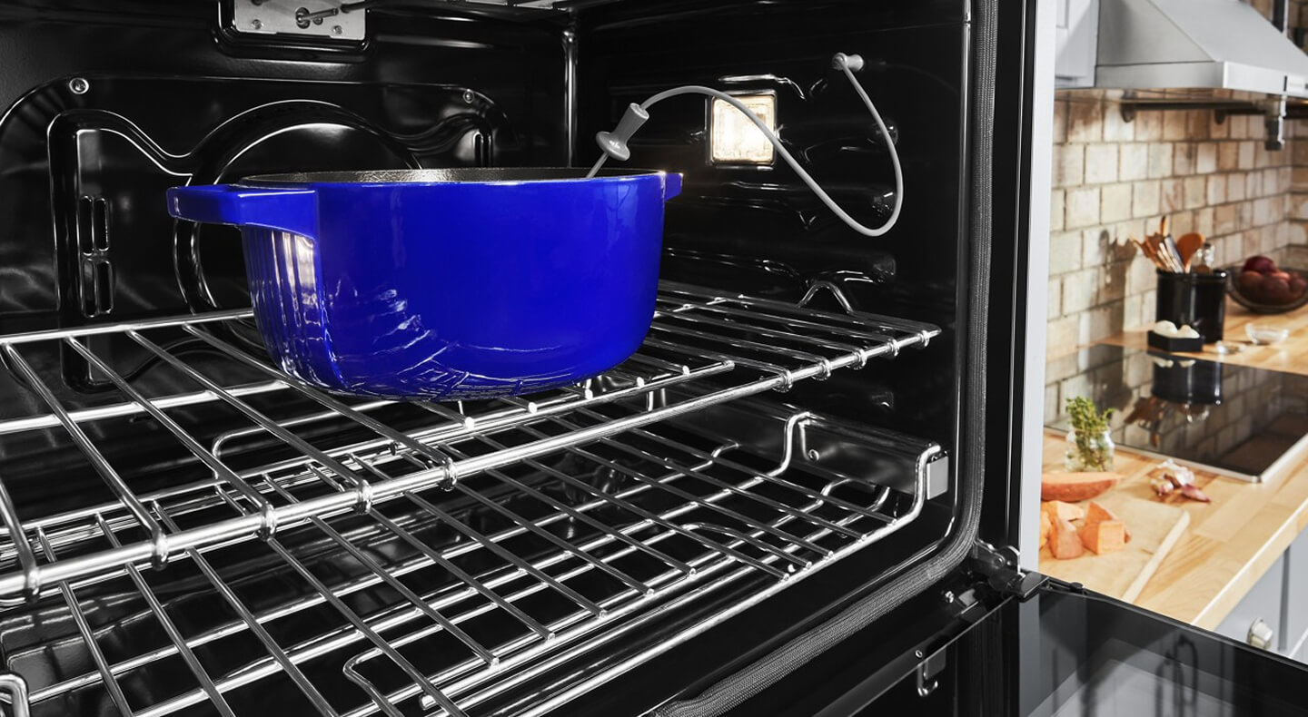 Blue casserole dish in an oven with a temperature monitor in it