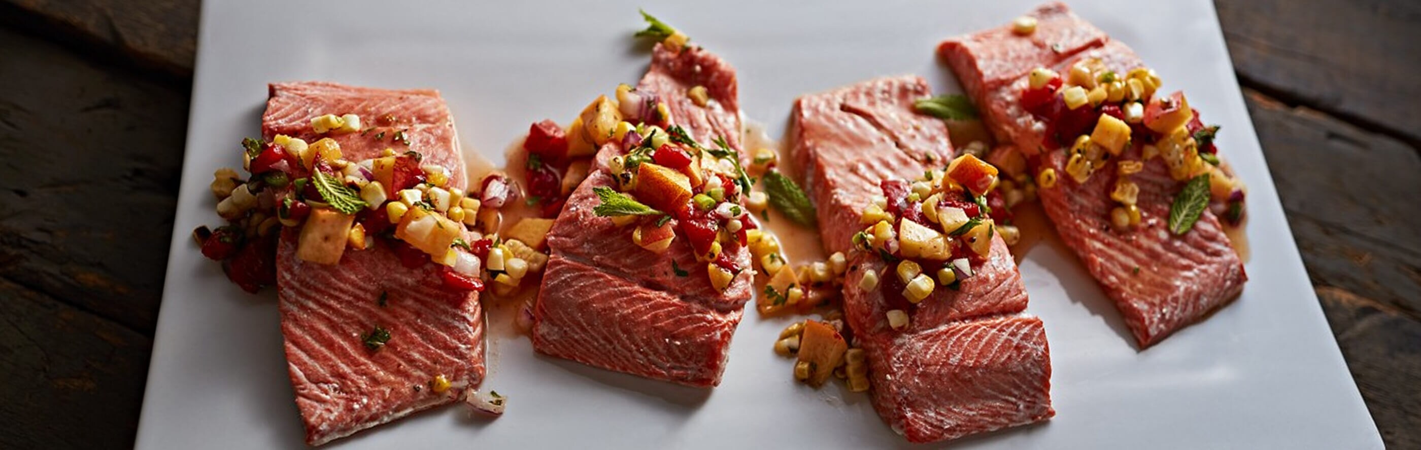 Saumon assaisonné avant la cuisson sous vide, posé sur une table rustique.