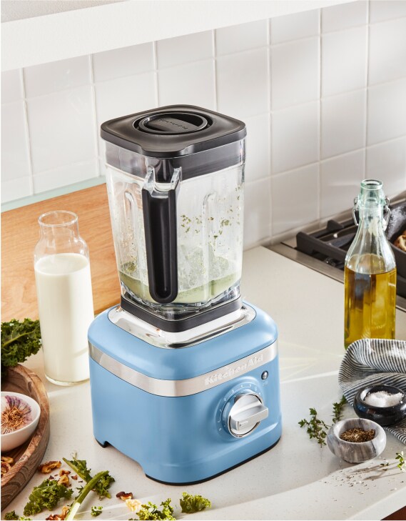 Un mélangeur KitchenAid sur un comptoir entouré par des ingrédients