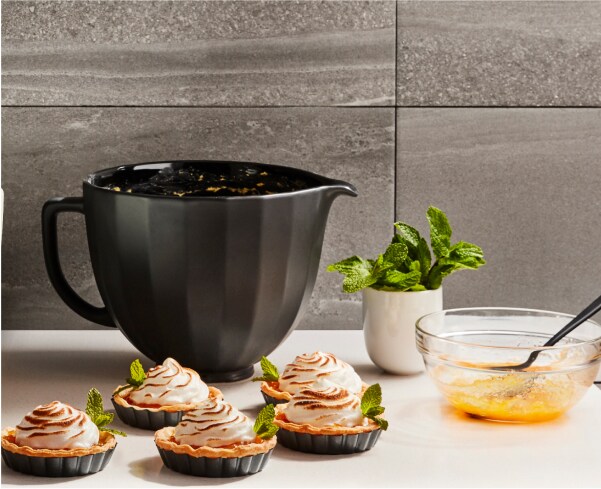 Un batteur sur socle KitchenAid avec plusieurs tartes prêtes