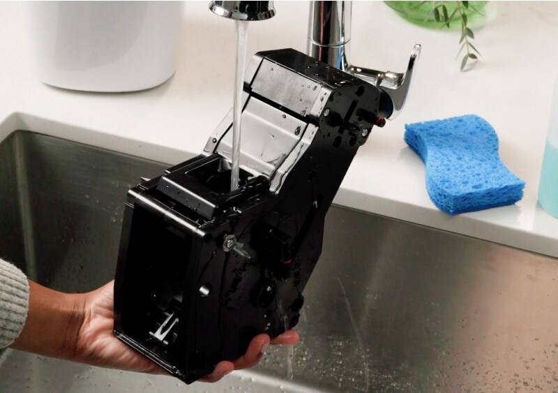 Espresso machine brew unit being cleaned