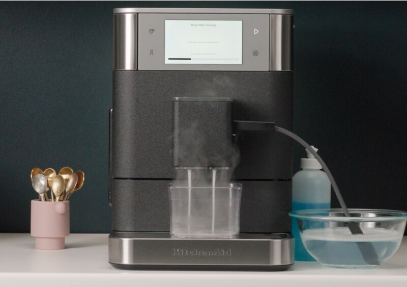 Espresso machine frother and wand being cleaned automatically