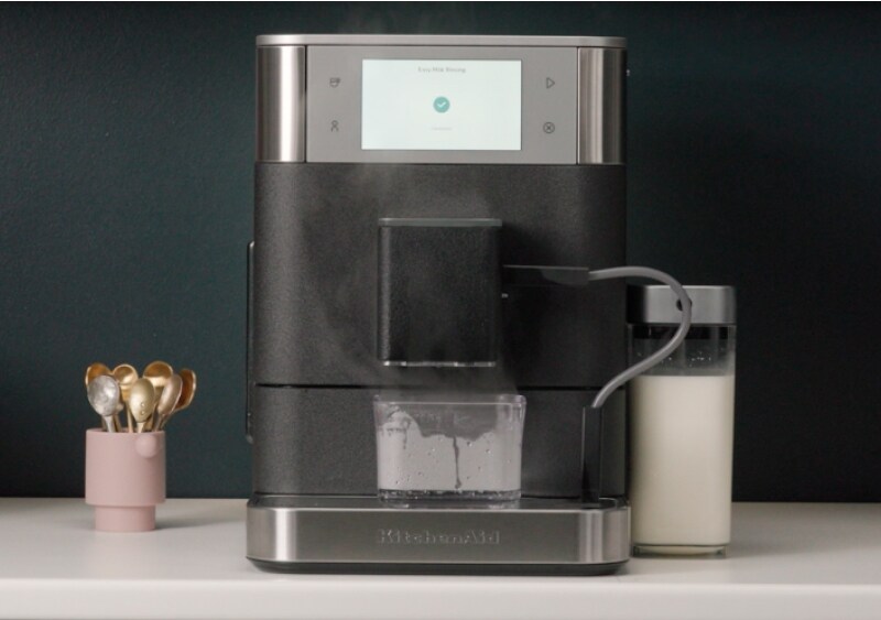 Espresso machine frother being cleaned automatically