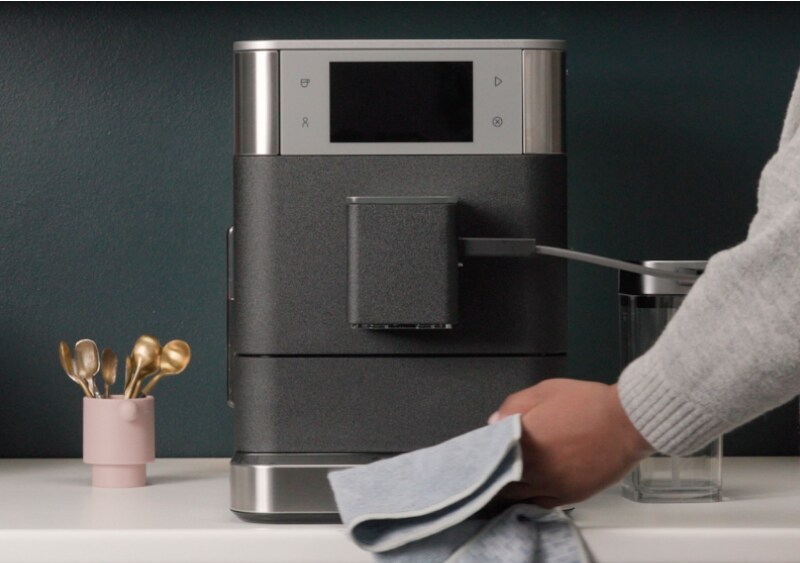 Person wiping an espresso machine