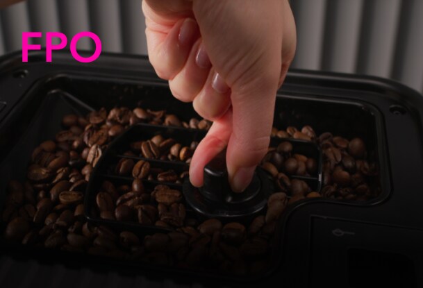 Person removing a bean hopper from an espresso machine