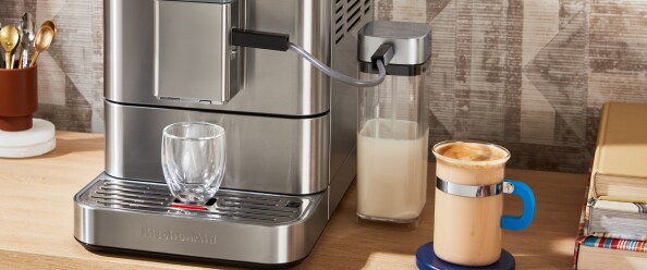 Woman steaming milk with an espresso machine.