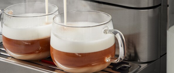 Two cups of espresso on an espresso machine drip tray