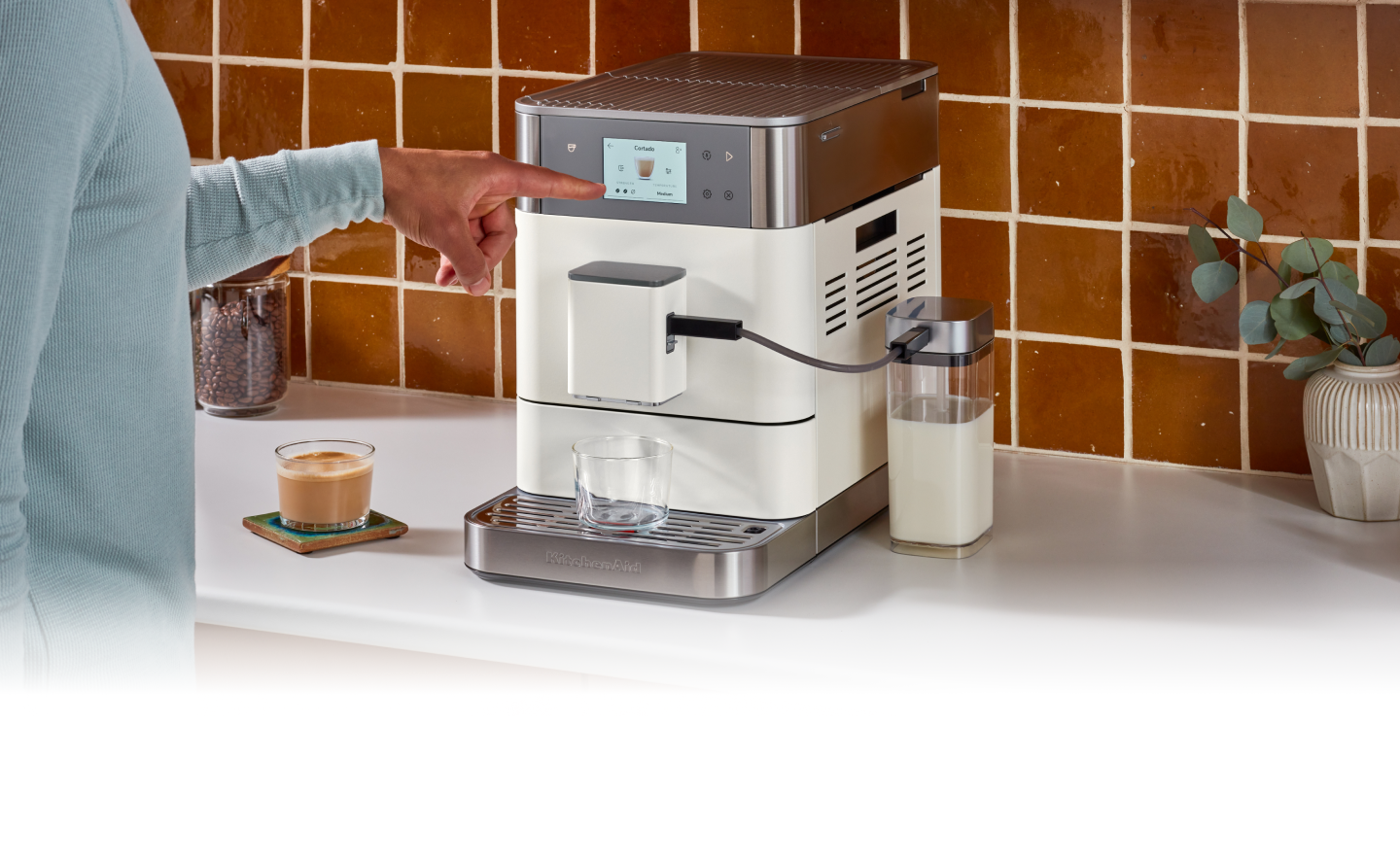 A person interacting with a KitchenAid® Fully Automatic Espresso Machine.