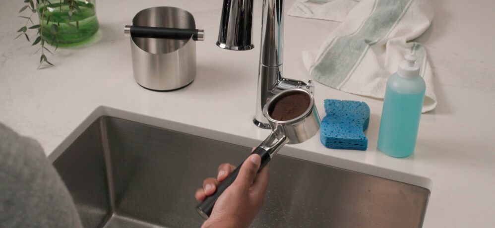 Person cleaning the espresso portafilter basket