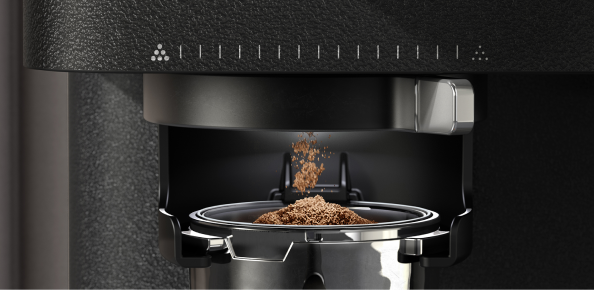 Closeup of espresso grinds pouring into a portafilter