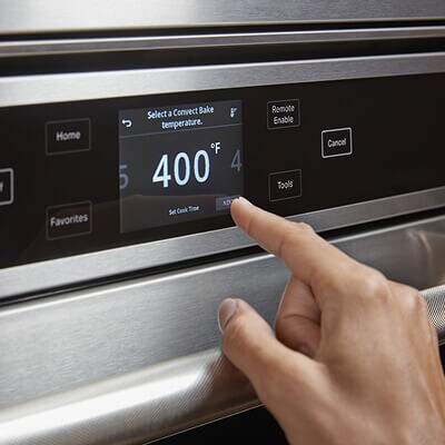 Une personne utilisant le panneau de commandes de son four