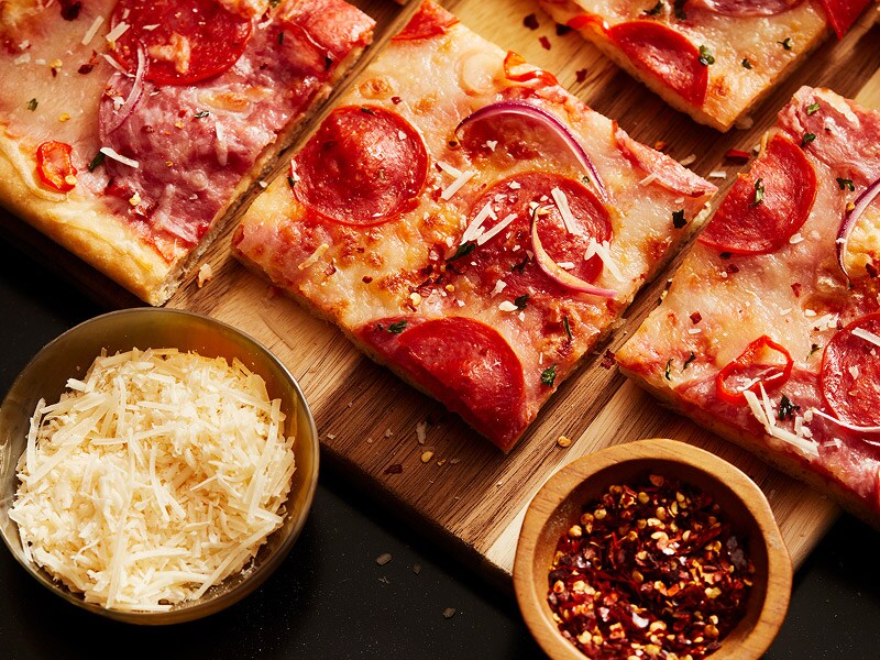 Une pizza coupée en carrés