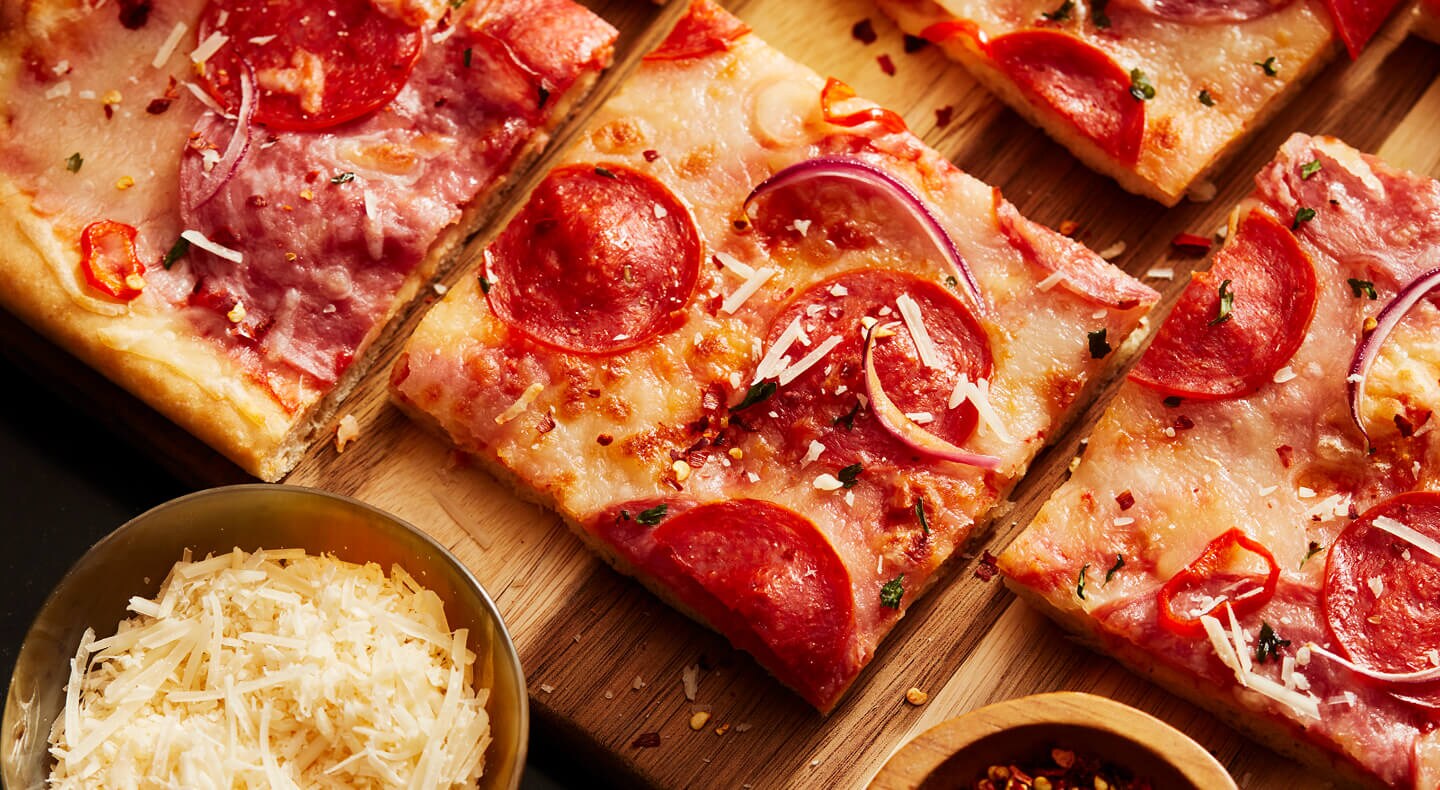 Une pizza coupée en carrés