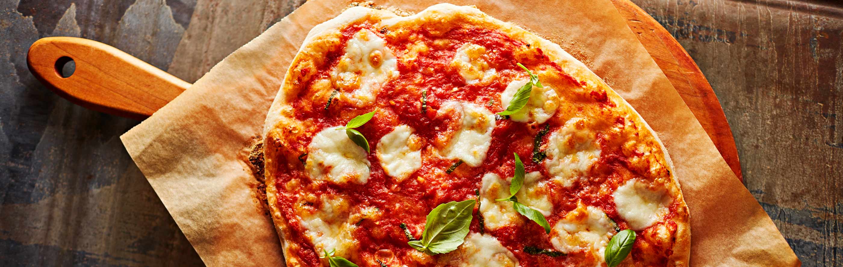 Une pizza sur une planche à découper en bois