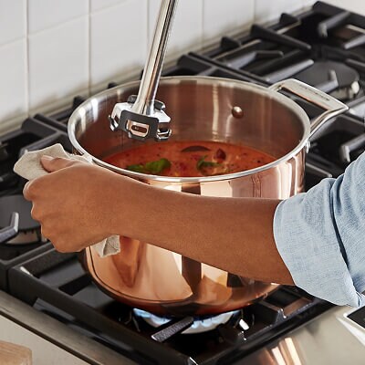 Une personne mélangeant de la sauce sur une surface de cuisson