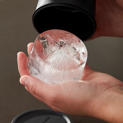 A person removing ice from an ice mold.