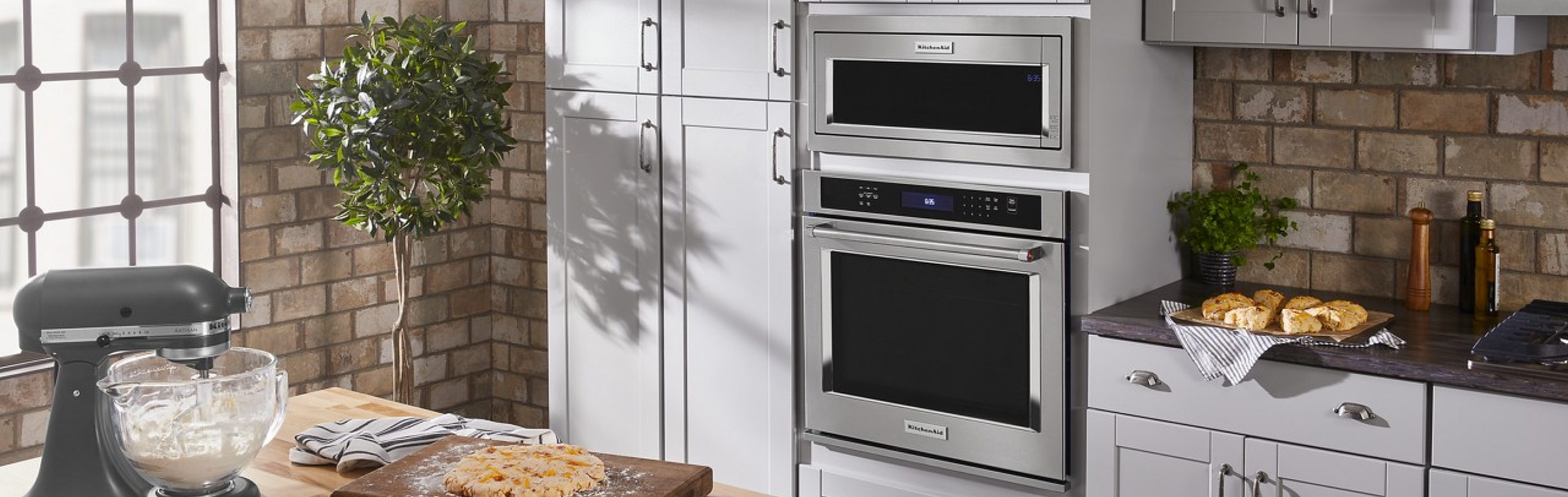 Kitchen with KitchenAid® combination wall oven set in white cabinets