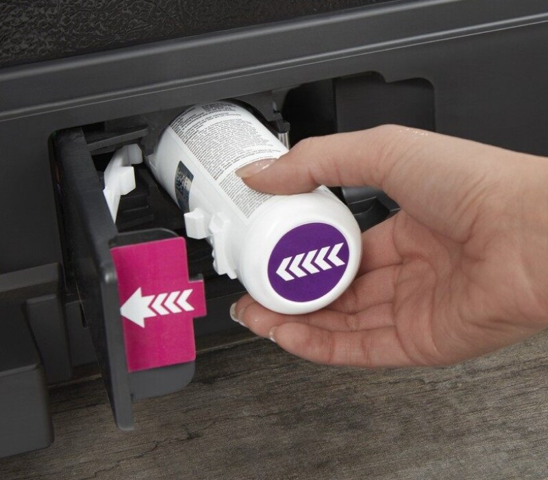 Hand removing an old water filter from a refrigerator