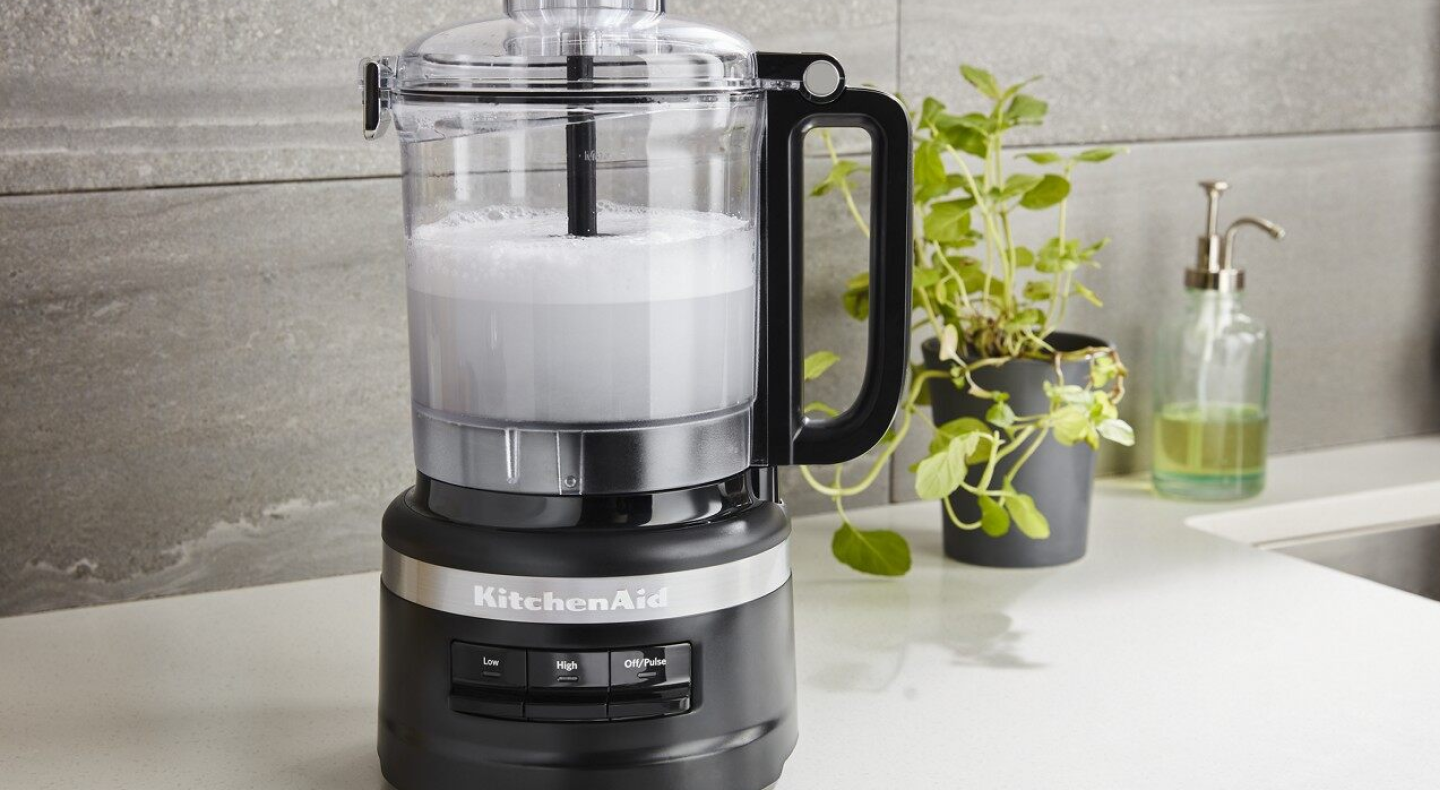 A frothy white liquid in a KitchenAid® food processor