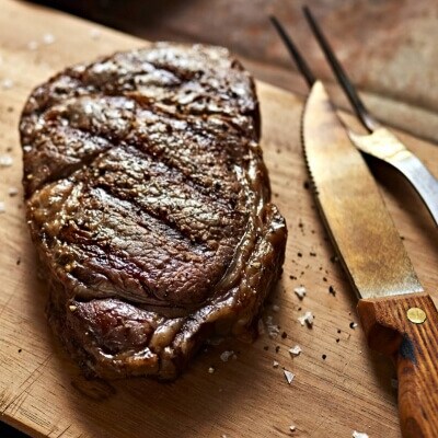 Steak cuit reposant sur une planche à découper