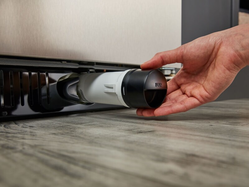 Une personne retire le filtre à eau d’un réfrigérateur