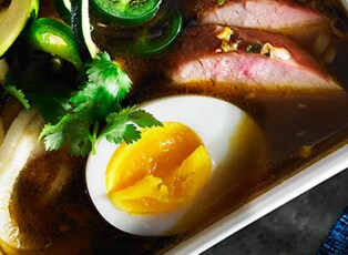 A rice bowl topped with ground pork, scallions and a soft-steamed egg.