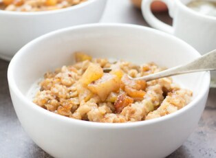 A bowl of oatmeal with blueberries and sliced strawberries on top.