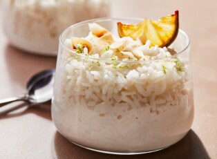 A bowl of rice pudding topped with cinnamon sticks and star anise.