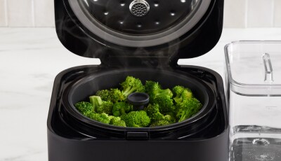 Broccoli florets in the steam basket of the Grain and Rice Cooker.